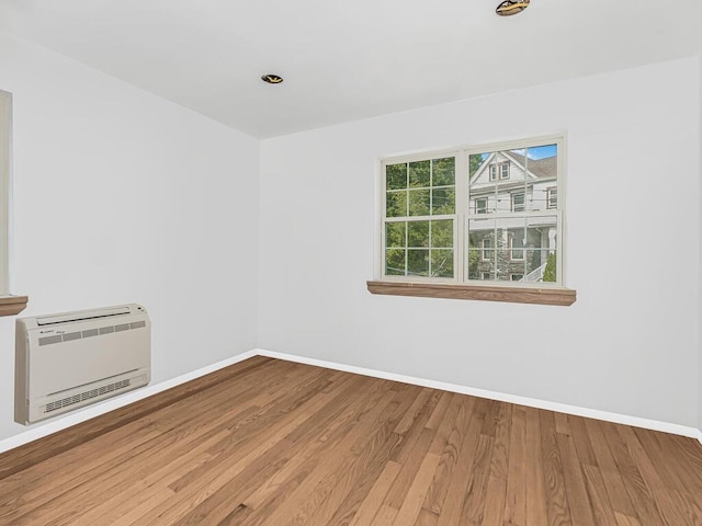 spare room featuring hardwood / wood-style floors and heating unit