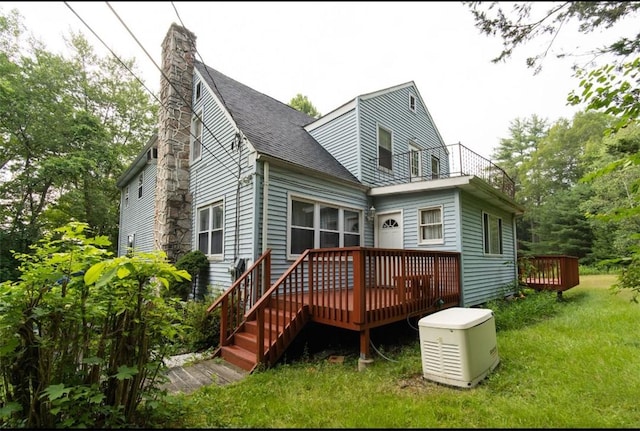 back of property featuring a lawn and a deck