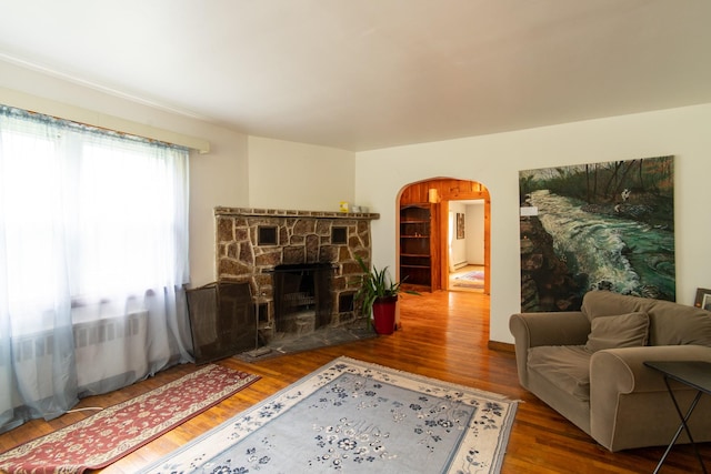 living room featuring hardwood / wood-style floors and a stone fireplace