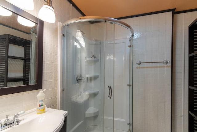 bathroom featuring decorative backsplash, a shower with door, and tile walls