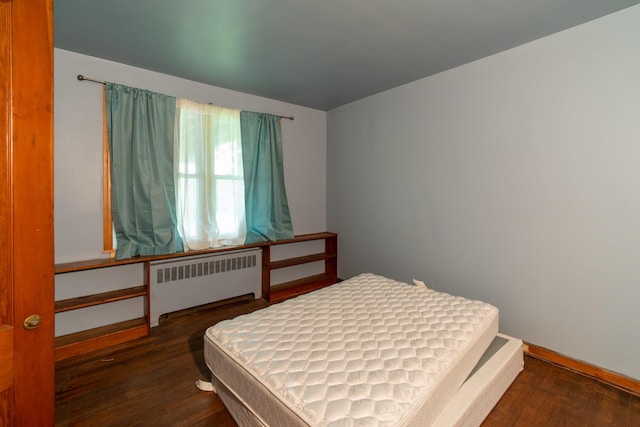 bedroom with radiator and dark wood-type flooring