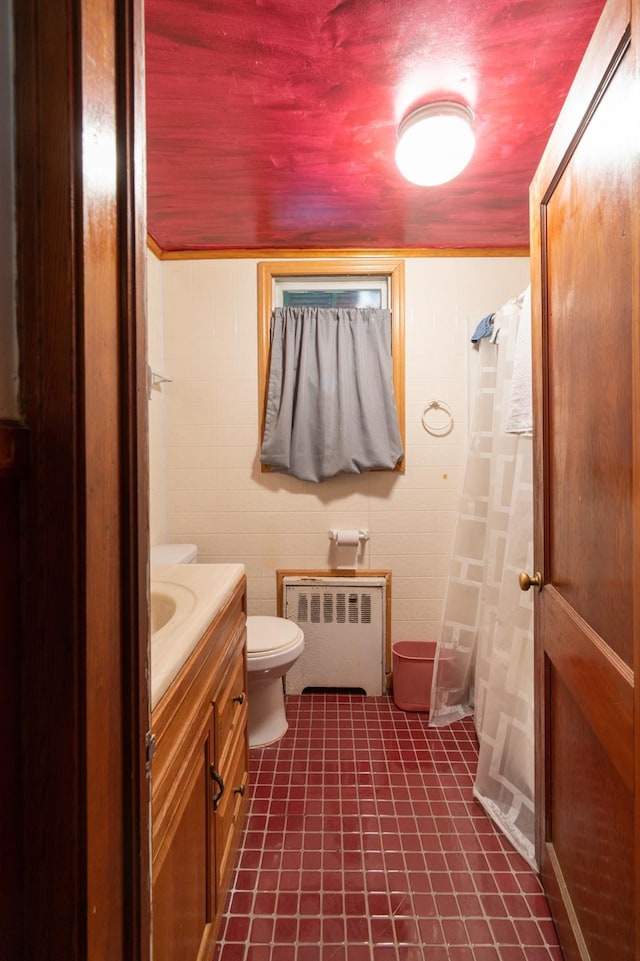 bathroom with radiator heating unit, vanity, and toilet