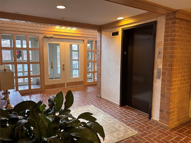 doorway to outside featuring elevator, crown molding, and french doors