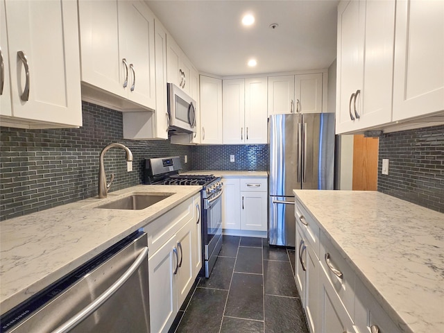 kitchen featuring decorative backsplash, sink, white cabinetry, and stainless steel appliances