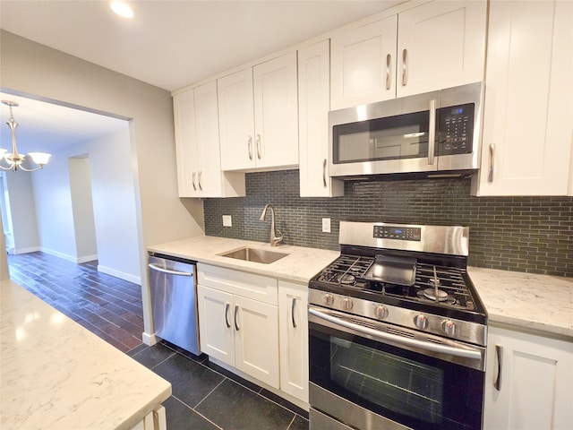 kitchen with light stone countertops, sink, stainless steel appliances, and white cabinetry