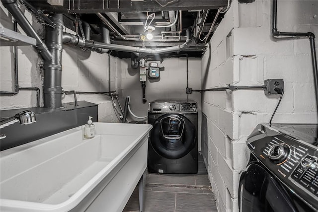 clothes washing area featuring washer / clothes dryer and sink