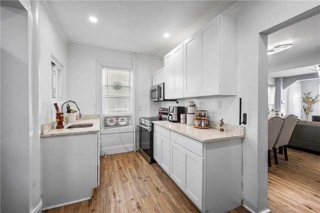 3026 Kingsland Ave, Bronx, NY 10469 - kitchen with sink, light stone counters, appliances with stainless steel finishes, white cabinets, and light wood-type flooring