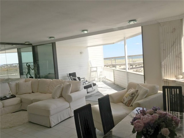 living room featuring a water view, a healthy amount of sunlight, and a wall of windows