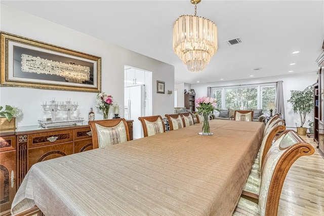 dining room with an inviting chandelier and light hardwood / wood-style flooring