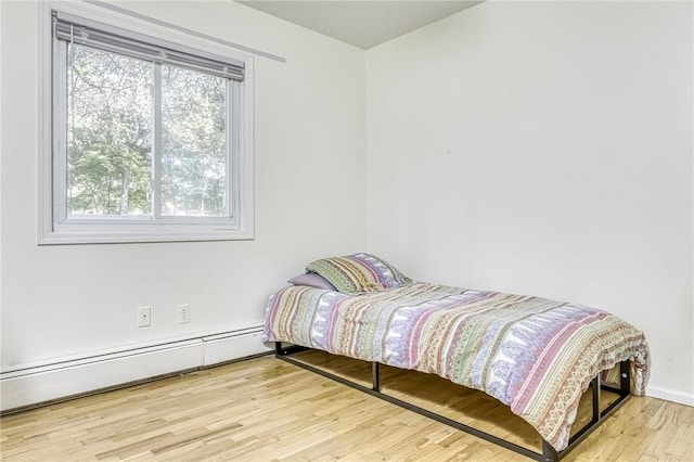 bedroom featuring light hardwood / wood-style flooring and baseboard heating