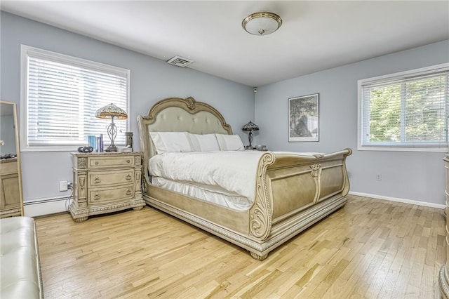 bedroom featuring light hardwood / wood-style flooring and a baseboard heating unit