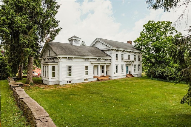 rear view of property featuring a lawn