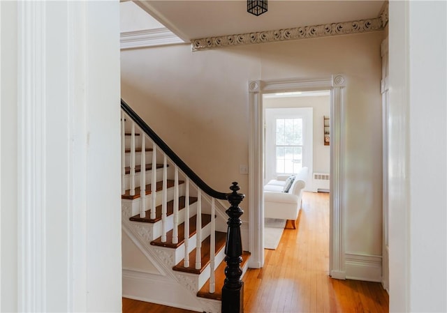 staircase with hardwood / wood-style floors and radiator