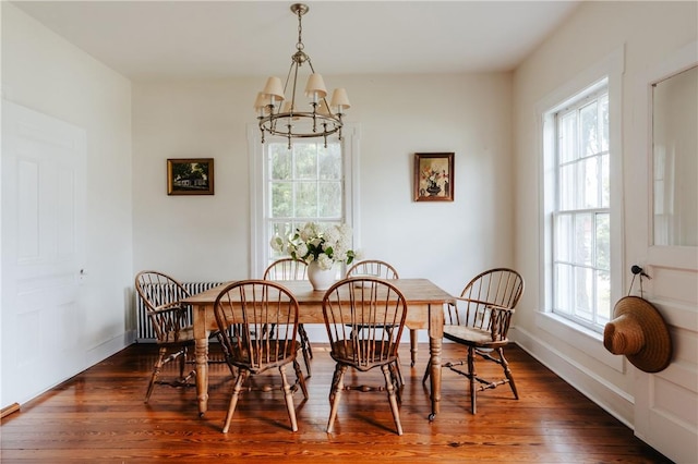 dining area with dark hardwood / wood-style flooring, plenty of natural light, and a notable chandelier