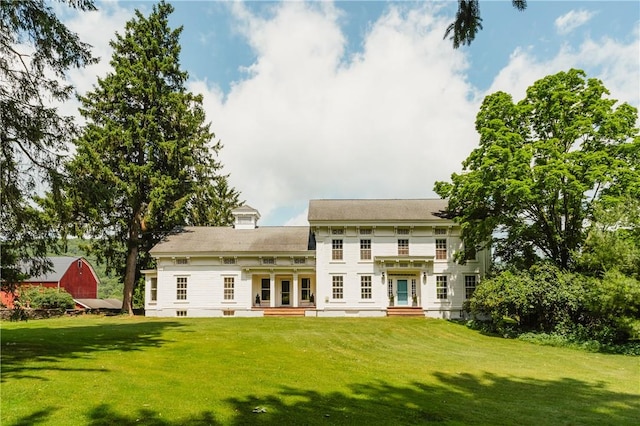 rear view of property with a lawn