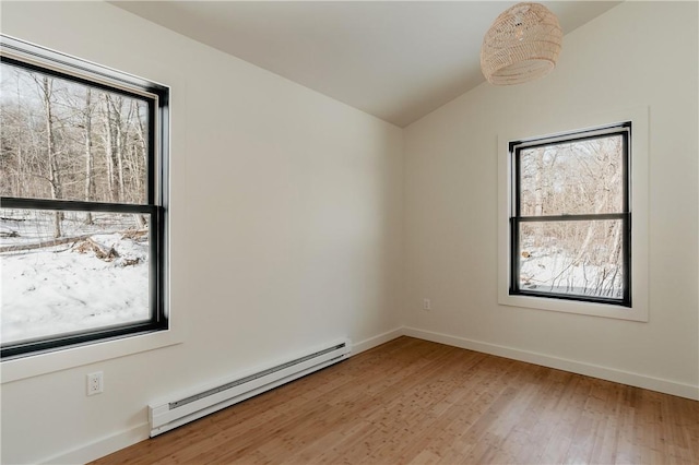 unfurnished room with hardwood / wood-style floors, lofted ceiling, and a baseboard heating unit