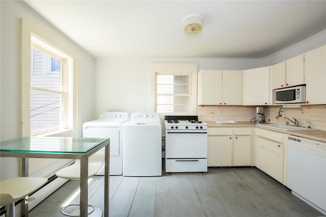 kitchen featuring white cabinetry, sink, backsplash, white appliances, and washer and dryer