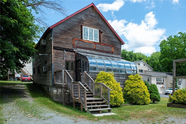 view of front facade with a sunroom and a front yard