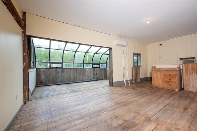 unfurnished room with a healthy amount of sunlight and wood-type flooring