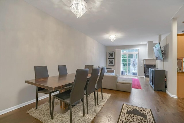 dining area featuring dark hardwood / wood-style flooring and an inviting chandelier