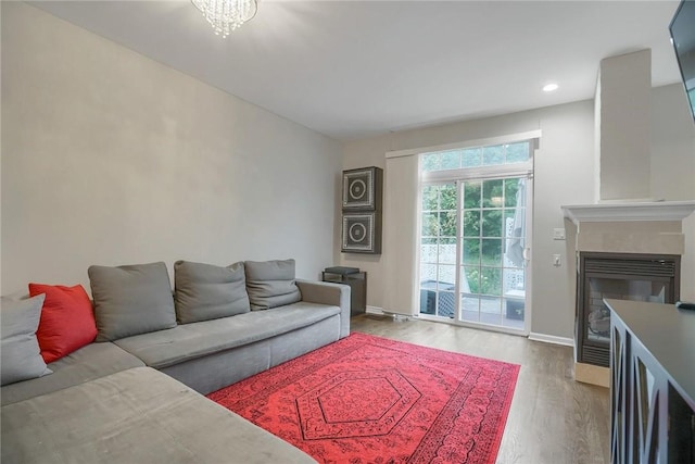 living room with an inviting chandelier and light hardwood / wood-style flooring