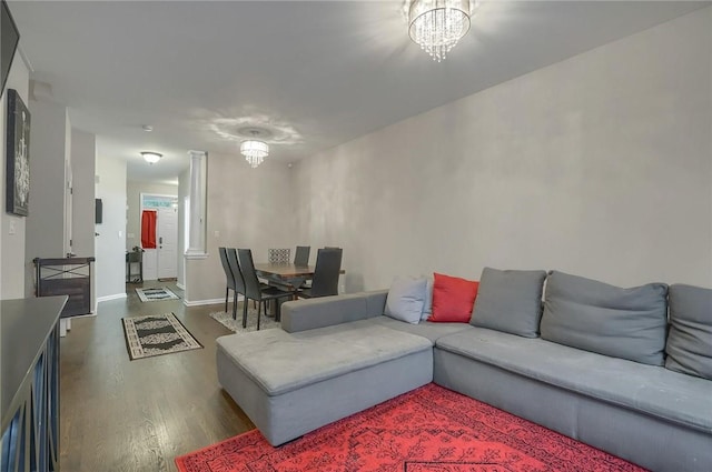 living room with a notable chandelier and dark wood-type flooring