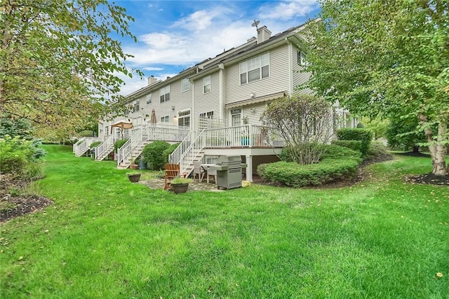 rear view of property featuring a yard and a deck