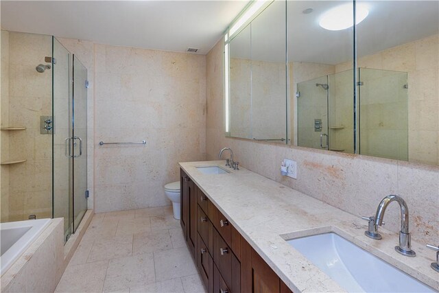 640 W 237th St Unit 20B, Bronx, NY 10463 - bathroom featuring tile walls, double vanity, a stall shower, tiled bath, and toilet