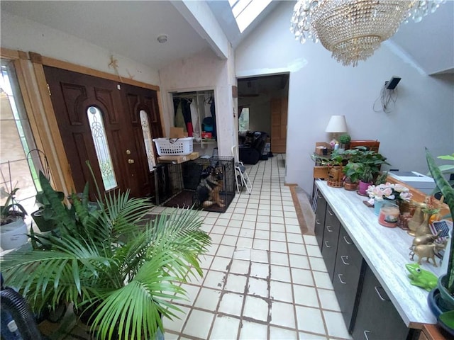 tiled entryway featuring lofted ceiling and an inviting chandelier