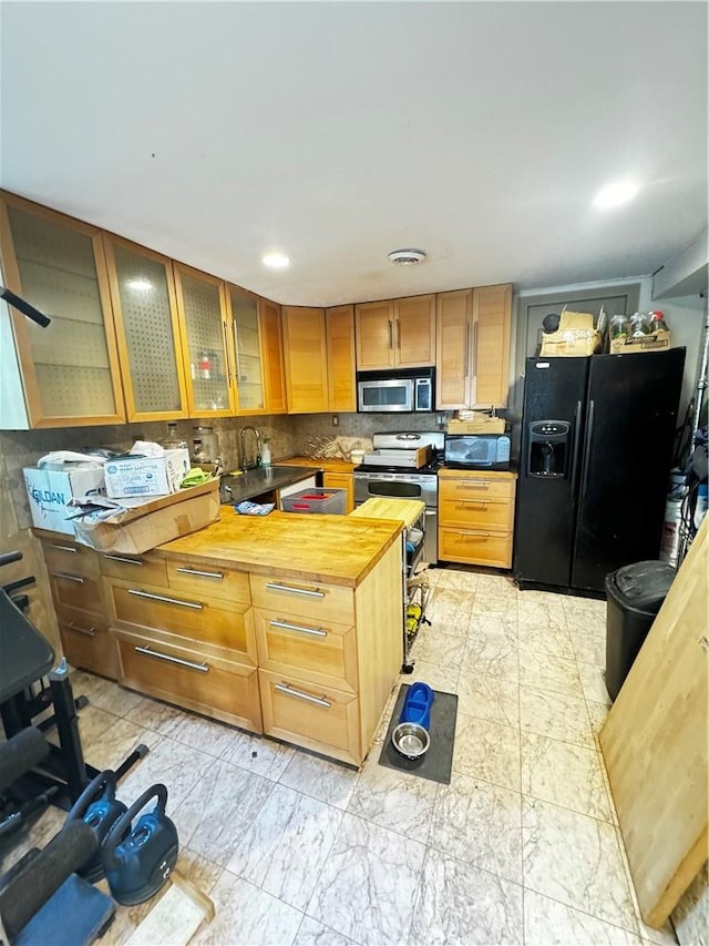 kitchen with tasteful backsplash, butcher block countertops, and black appliances