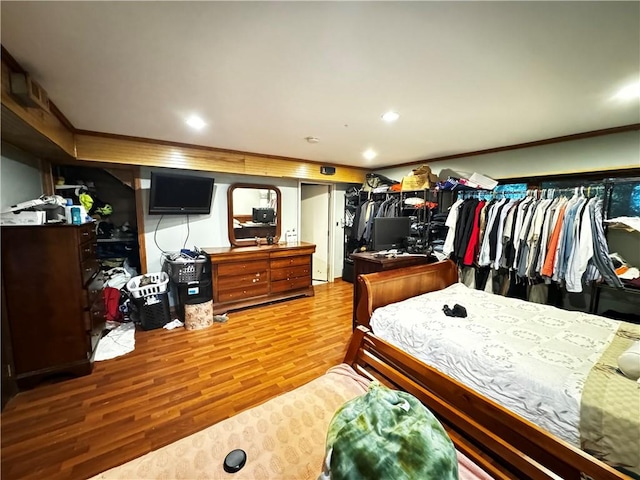 bedroom featuring crown molding, a closet, and hardwood / wood-style flooring