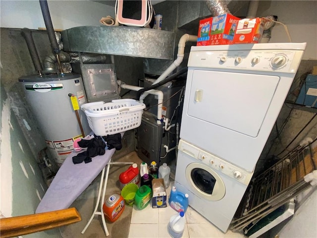 laundry room with tile patterned floors, stacked washer / dryer, and water heater