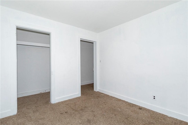 unfurnished bedroom featuring light colored carpet and a closet