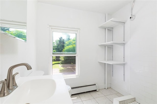 bathroom featuring baseboard heating and sink