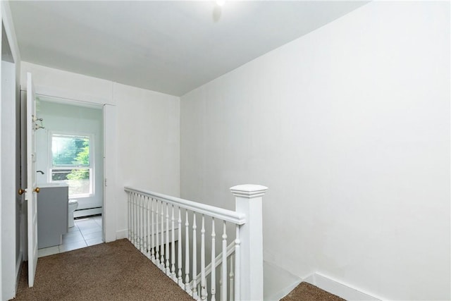 hallway with light carpet and a baseboard radiator