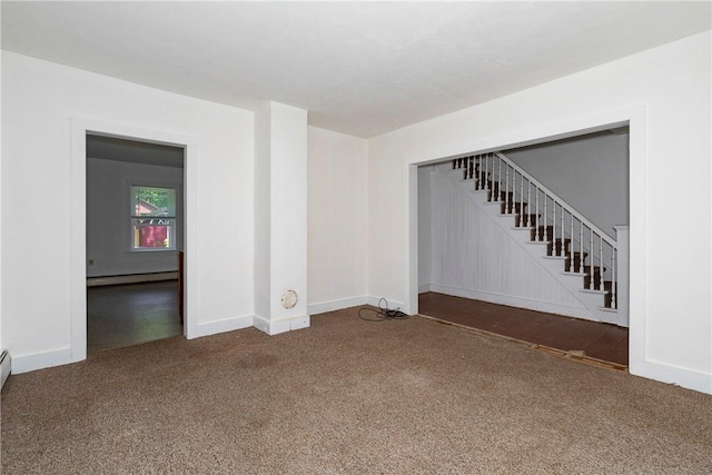 carpeted empty room with a baseboard heating unit