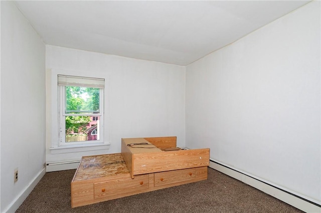 interior space with dark carpet and baseboard heating