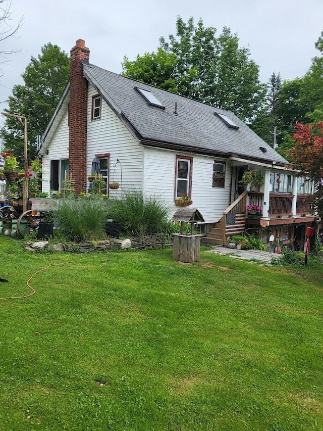 rear view of house featuring a lawn