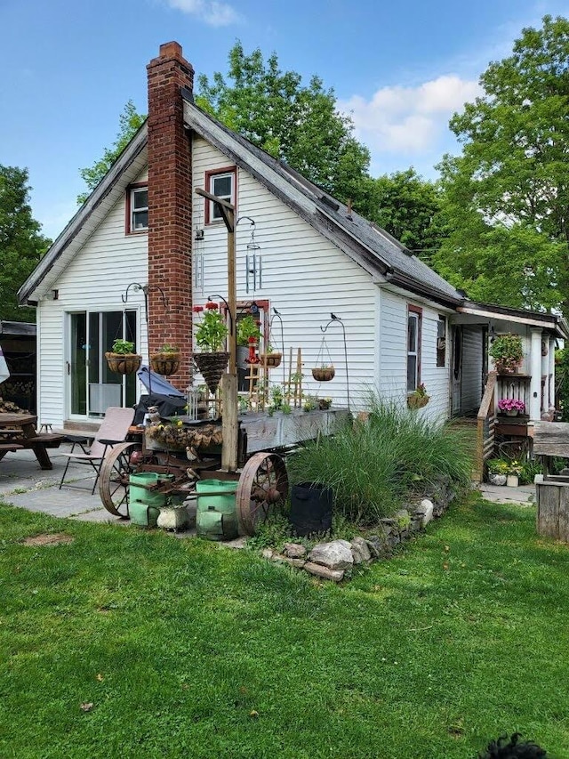 back of property featuring a patio area and a lawn