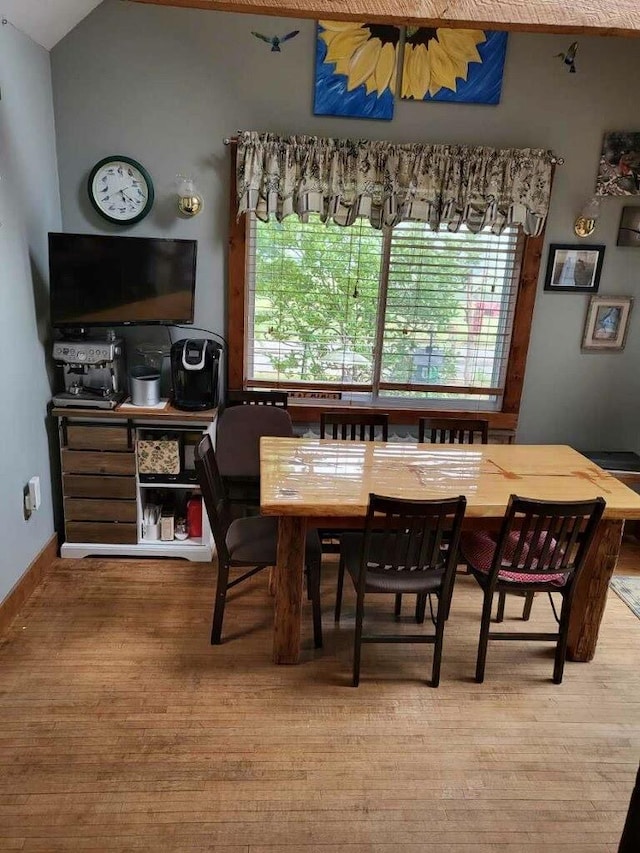 dining area featuring wood-type flooring and lofted ceiling