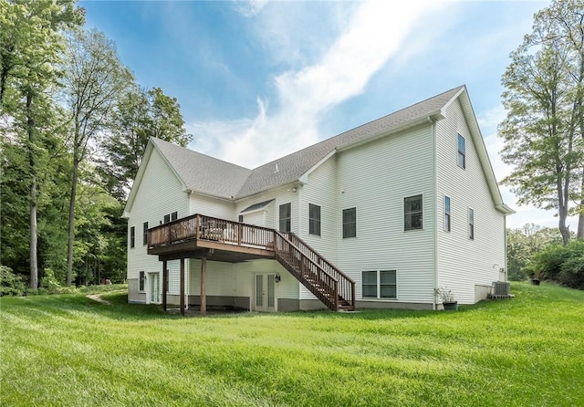 rear view of property featuring a yard, central AC unit, and a wooden deck