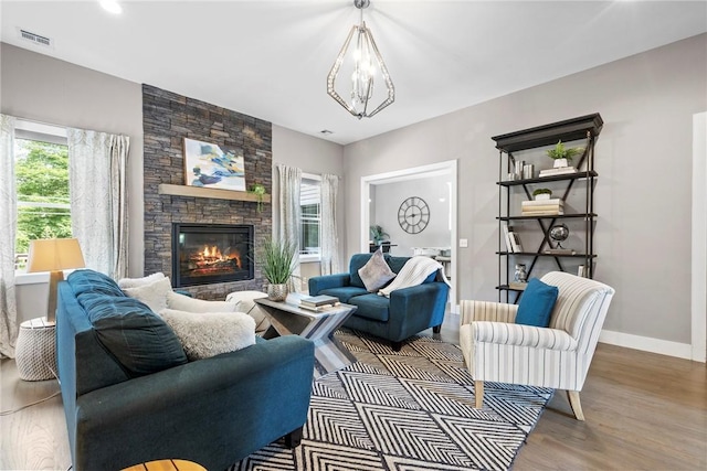 living room featuring hardwood / wood-style floors, a fireplace, and an inviting chandelier