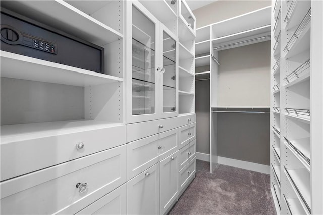 walk in closet featuring dark colored carpet