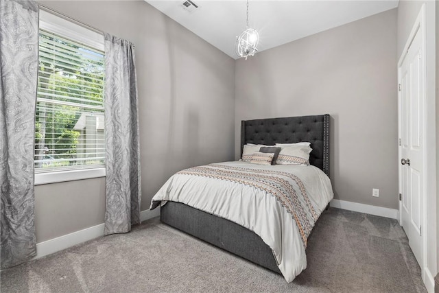 carpeted bedroom featuring a notable chandelier