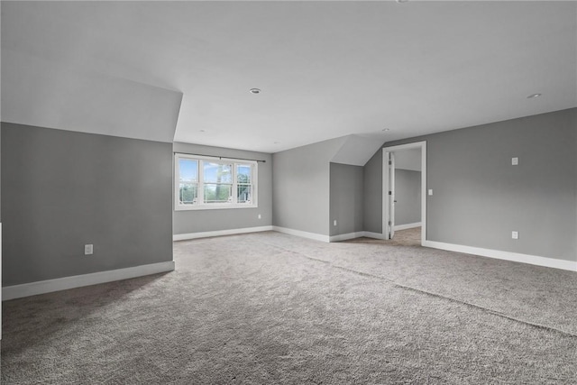 unfurnished room with carpet and vaulted ceiling