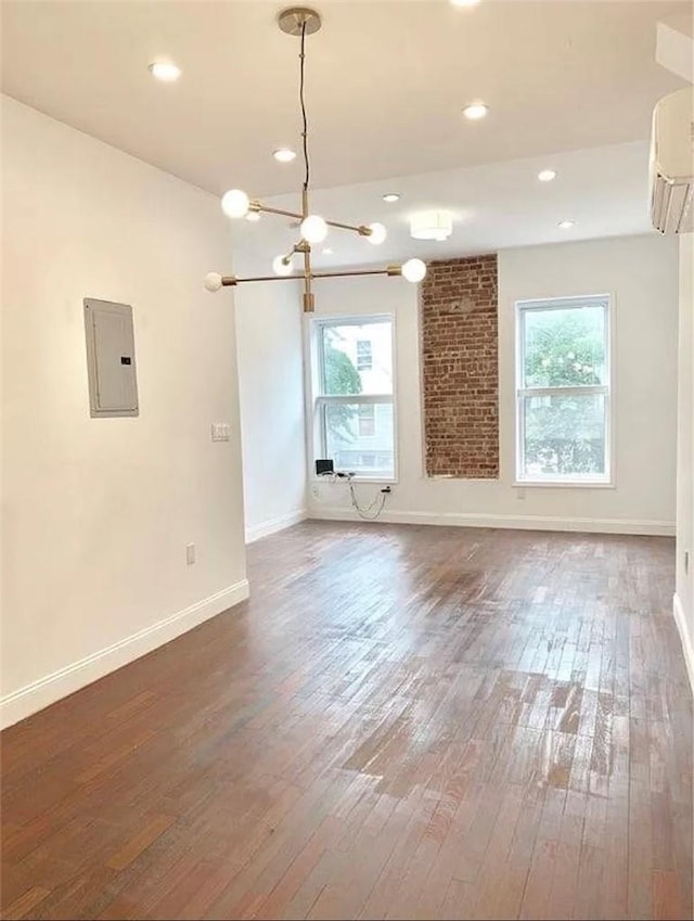 unfurnished living room featuring a healthy amount of sunlight, dark wood-type flooring, and electric panel