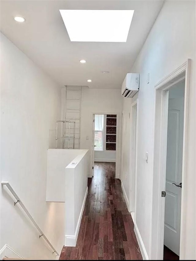 hall featuring a skylight, dark wood-type flooring, and a wall mounted air conditioner