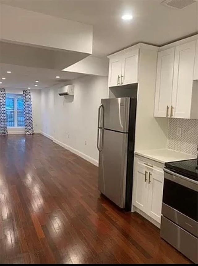 kitchen featuring backsplash, stainless steel appliances, white cabinetry, and dark hardwood / wood-style floors