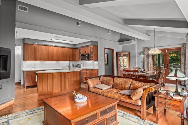 living room featuring french doors, lofted ceiling with beams, and light hardwood / wood-style flooring