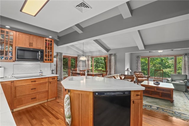 kitchen with vaulted ceiling with beams, a center island with sink, black appliances, and french doors